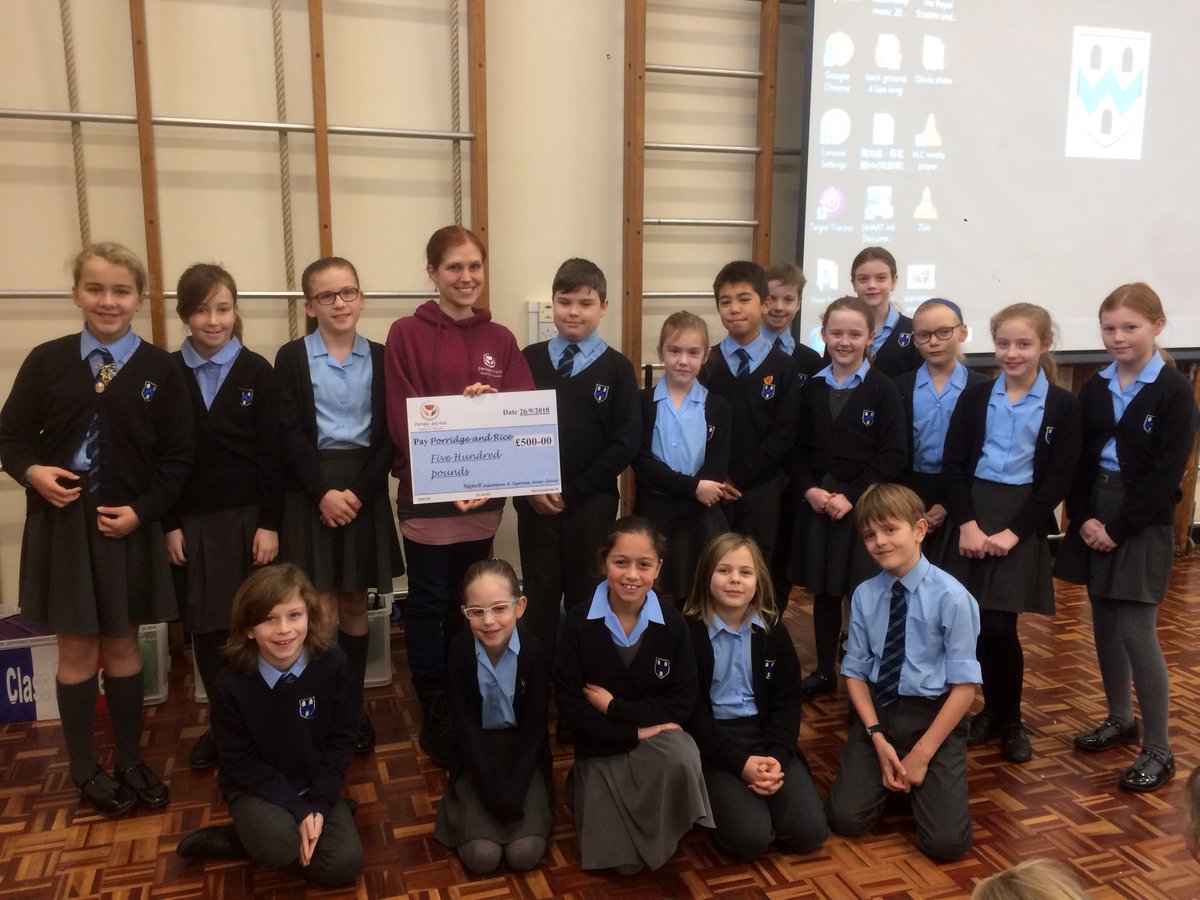 Emma Ballinger, vice-chair of the charity Porridge and Rice accepts a cheque from the school