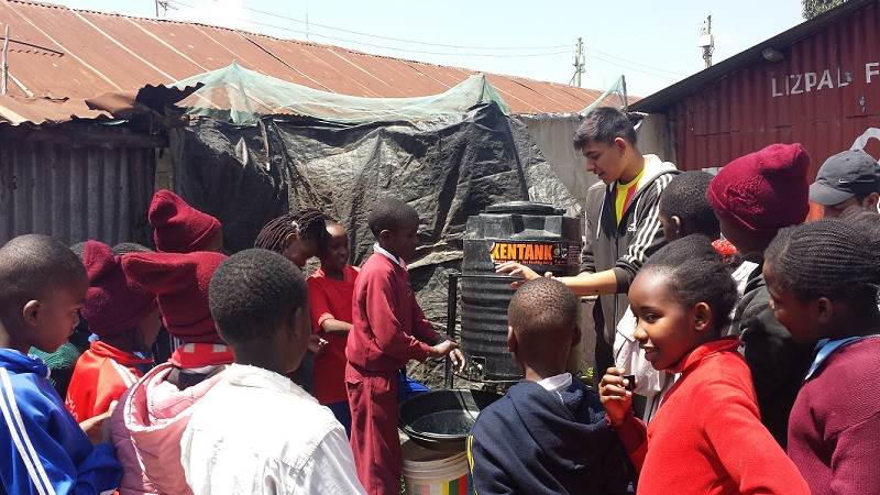 Jay, a volunteer with Porridge and Rice during his A level year, works with children to make sure they wash their hands properly