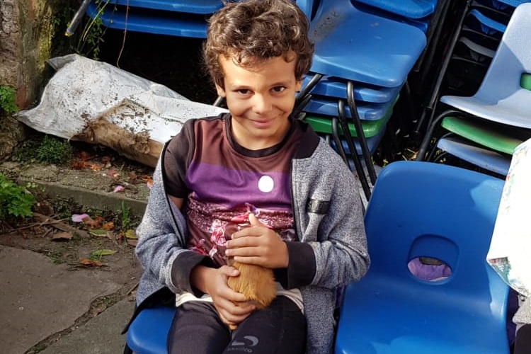 young man holds a baby guinea pig at the Porridge and Rice petting day in Whitton